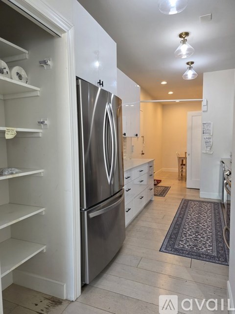 A kitchen with a refrigerator and a drawer.