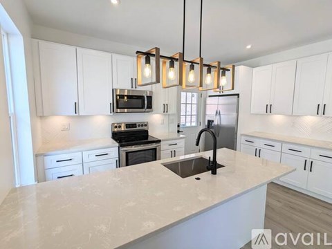 A kitchen with white cabinets and a marble countertop.