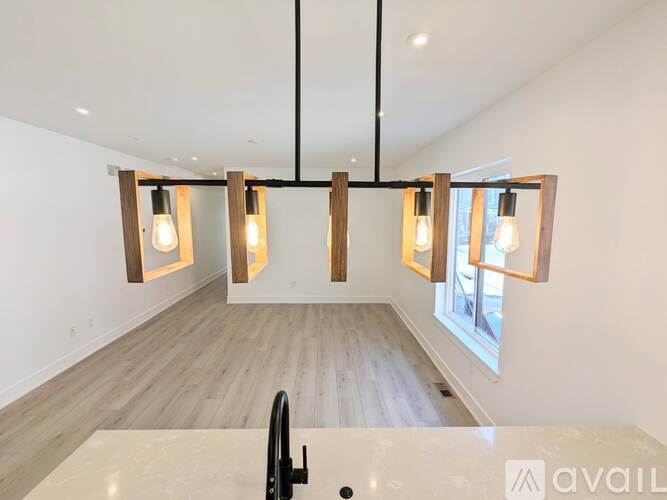 A modern kitchen with a large island and pendant lights.