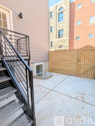 A staircase with a metal railing leads up to a door on a building.