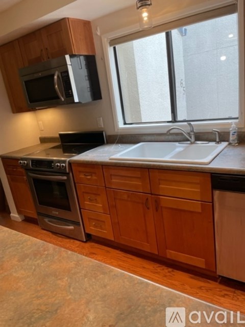 A kitchen with wooden cabinets and a stainless steel sink.