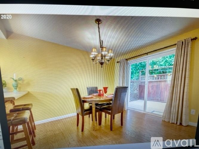 A dining room with a wooden table and chairs.