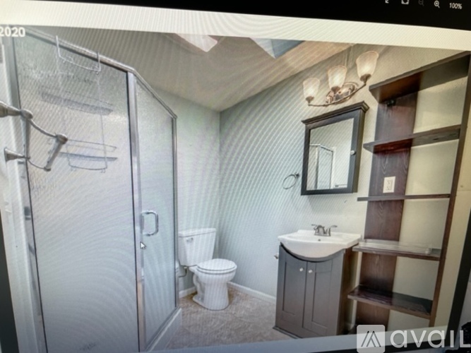 A bathroom with a toilet, sink, and shower.