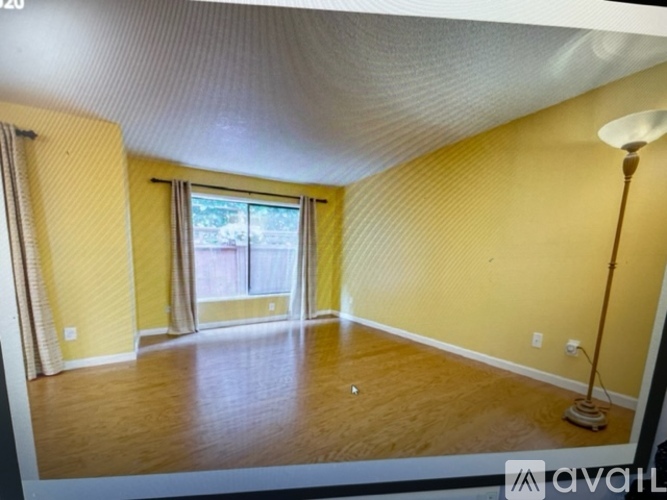 A room with yellow walls and a window with curtains.