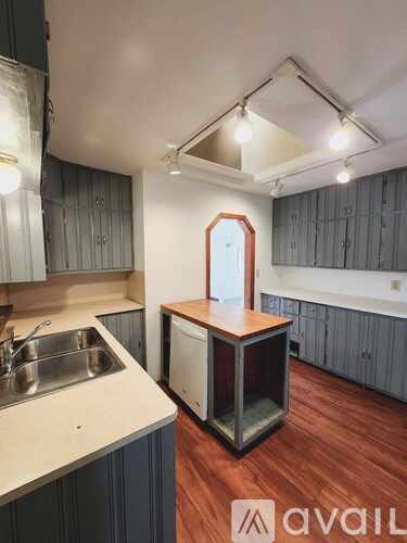 A kitchen with a sink and a wooden island.