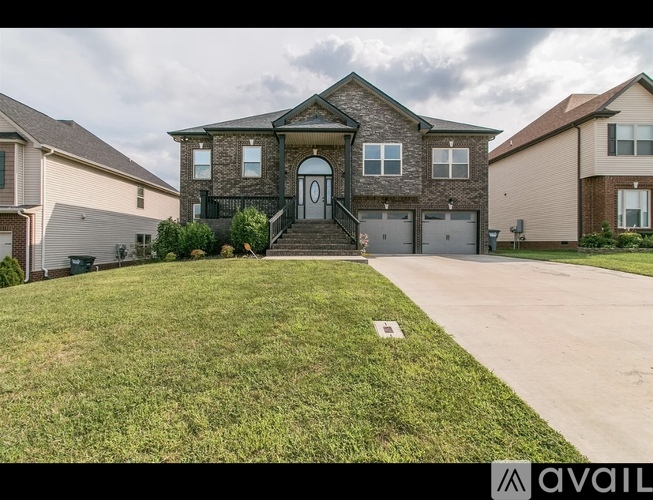 A house with a front yard and a driveway is available for sale.