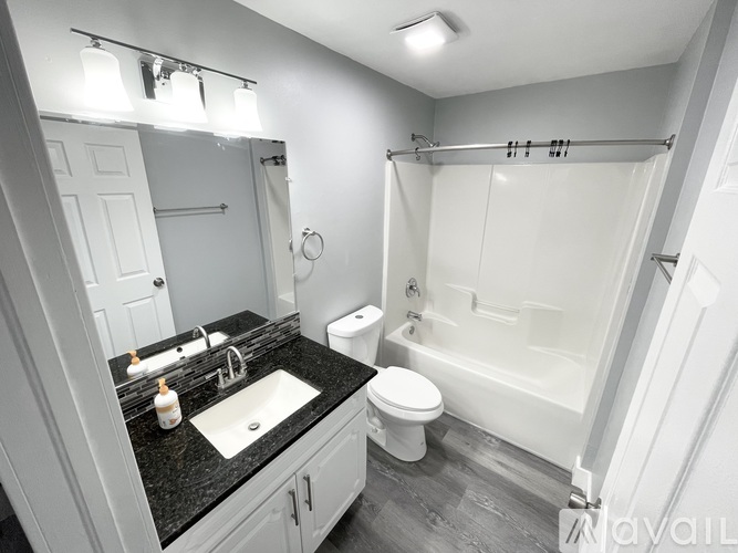 A bathroom with a sink, toilet, and bathtub.