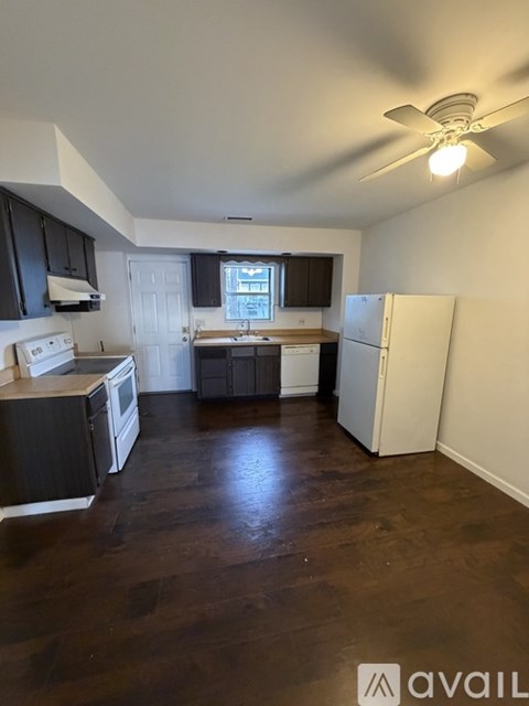 A kitchen with black cabinets and a white stove top oven.