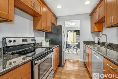A kitchen with wooden cabinets and a black refrigerator.