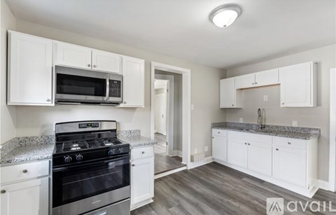 A kitchen with white cabinets and a black stove top oven.