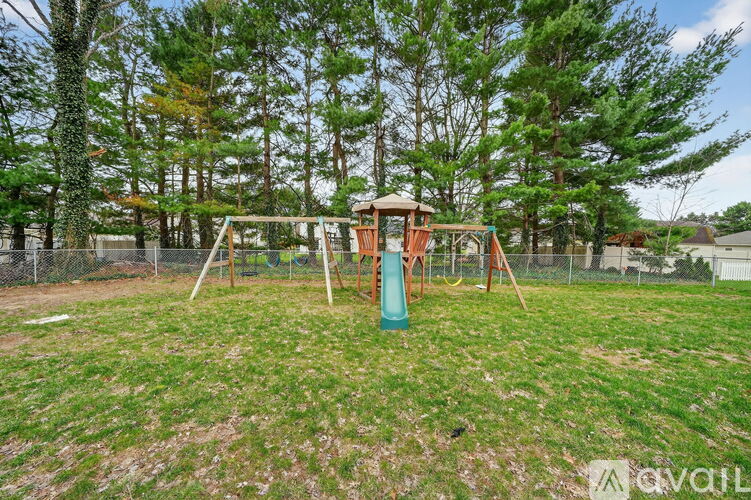 A playground with a swing set and a slide in a grassy area.
