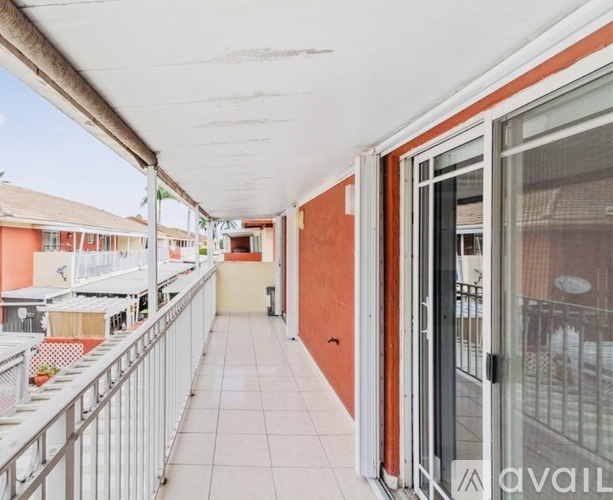 A balcony with a white railing and a view of a building.
