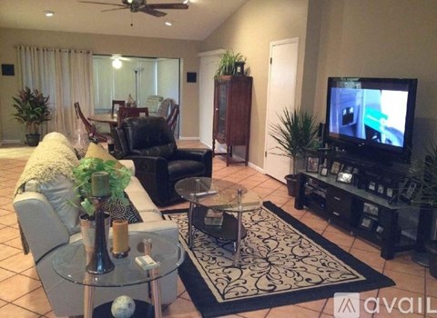 A living room with a television and a glass coffee table.