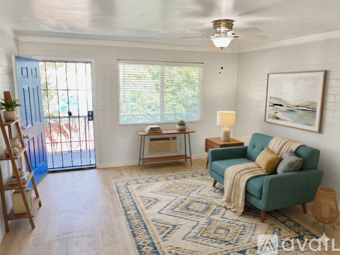 A living room with a green couch and a rug.