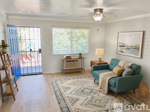 A living room with a green couch and a rug.