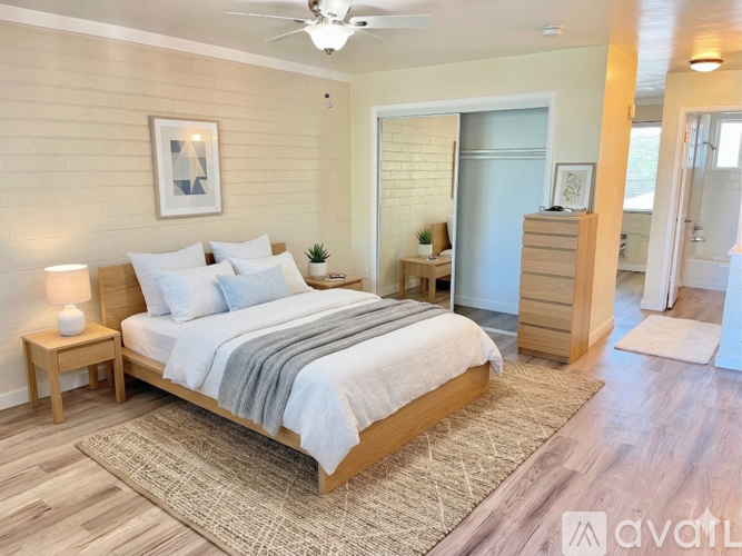 A bedroom with a bed, nightstand, and lamp.