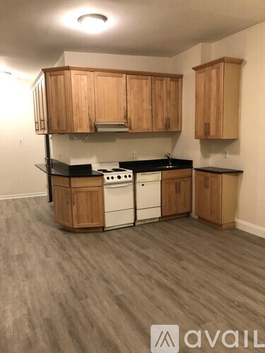 A kitchen with wooden cabinets and black countertops.