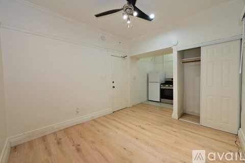A room with wooden flooring and a ceiling fan.