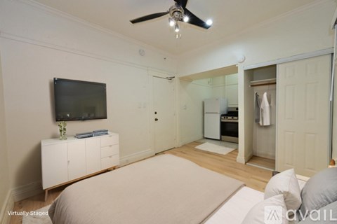 A bedroom with a bed, dresser, and television.