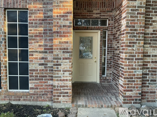 A brick house with a white door and window.