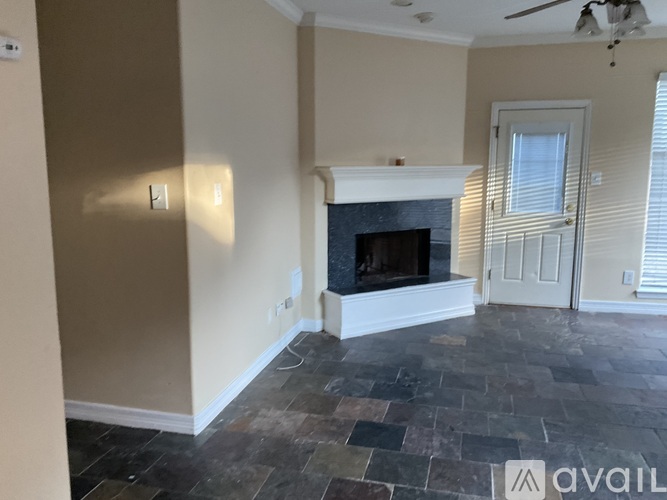 A living room with a fireplace and slate flooring.