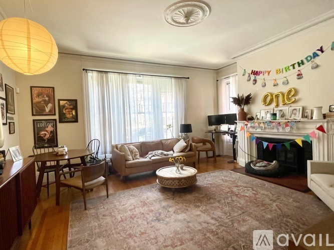 A living room with a birthday banner and a fireplace.