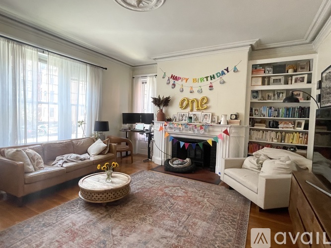 A living room with a couch, a coffee table, and a bookshelf.