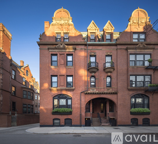A large red brick building with a balcony on the second floor.