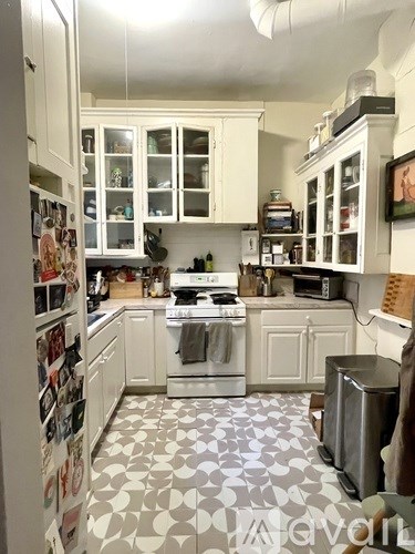 A kitchen with white cabinets and a patterned floor.
