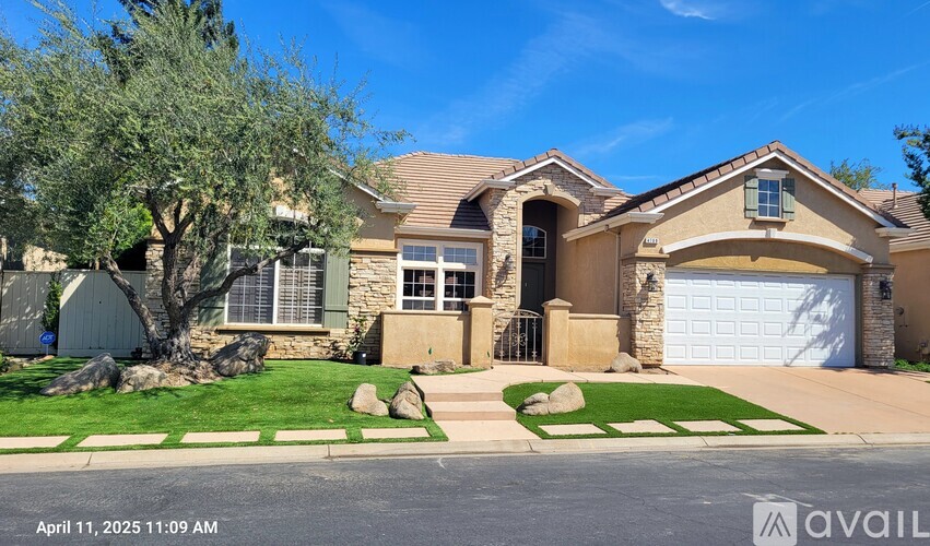 A house with a tree in front and a garage door.