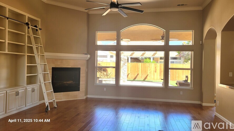 A living room with a fireplace and a ladder.