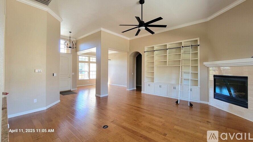 A spacious living room with a fireplace and built-in shelves.