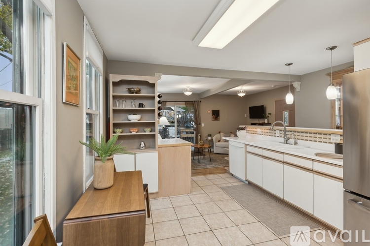 A kitchen with white cabinets and a wooden island.