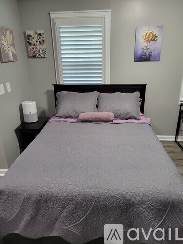 A bed with a white comforter and a pillow with a geometric pattern.