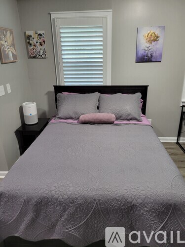 A bed with a white comforter and a pillow with a geometric pattern.