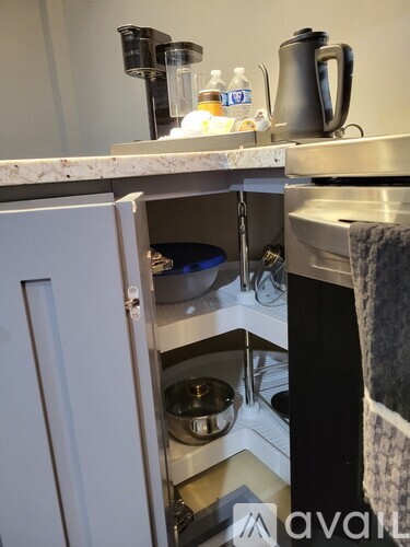 A kitchen with a white cabinet and a black towel hanging on the oven.