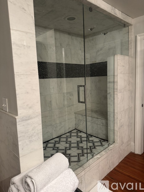 A marble bathroom with a glass shower door.