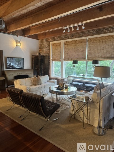 A living room with a black chair and a white couch.
