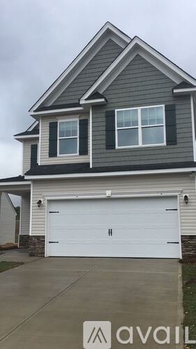 A two-story house with a garage and a driveway.