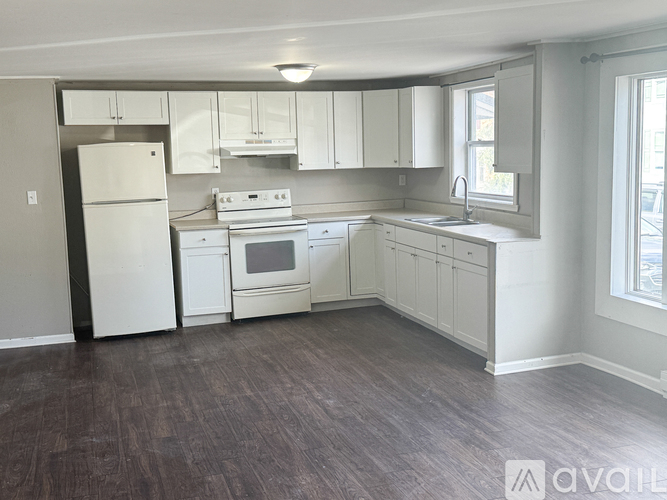 A kitchen with white appliances and cabinets.