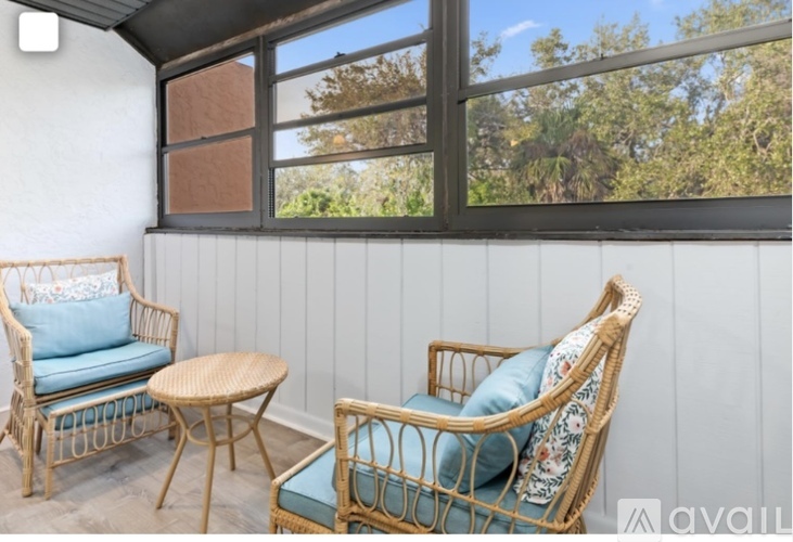 A patio with two chairs and a table.