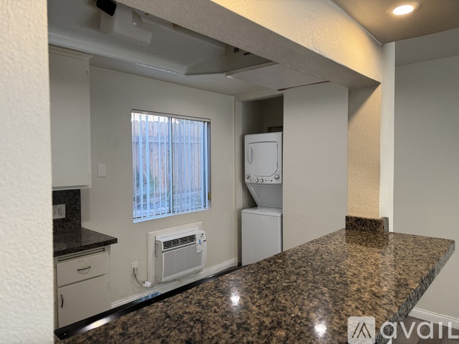 A kitchen with granite countertops and white appliances.
