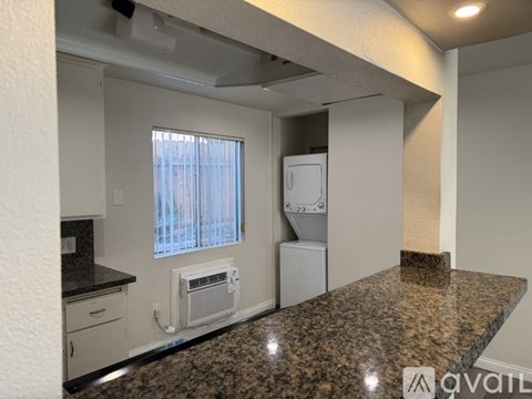 A kitchen with granite countertops and white appliances.
