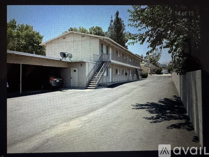 A building with a satellite dish on the roof and a car parked in front.