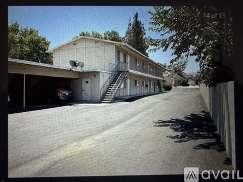 A building with a satellite dish on the roof and a car parked in front.