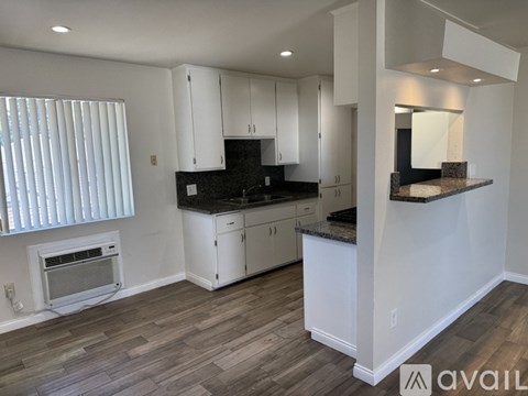 A bathroom with a toilet, sink, and cabinet.