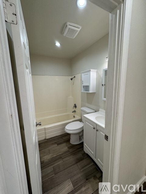 A bathroom with a toilet, sink, and bathtub.
