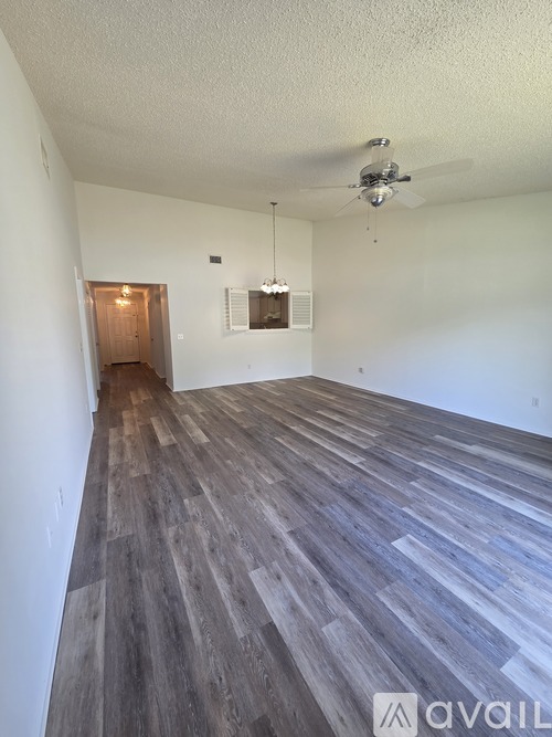 A room with wooden flooring and a ceiling fan.