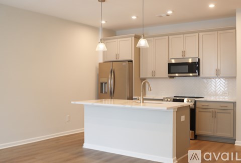 A kitchen with a white island and wooden cabinets.