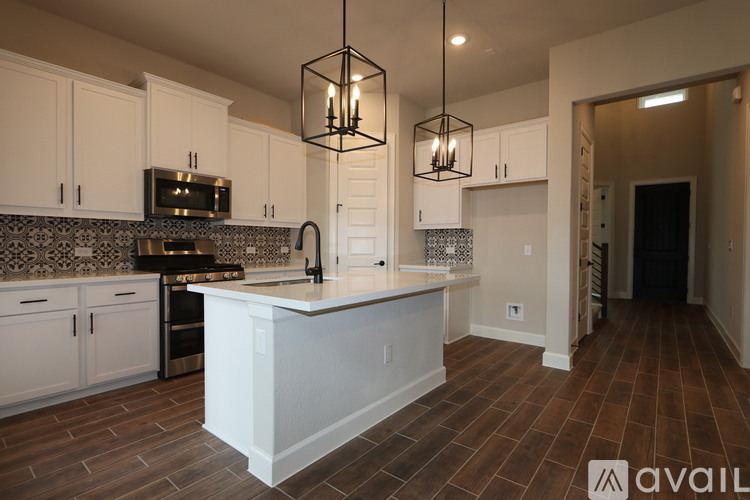 A kitchen with white cabinets and a wooden floor.